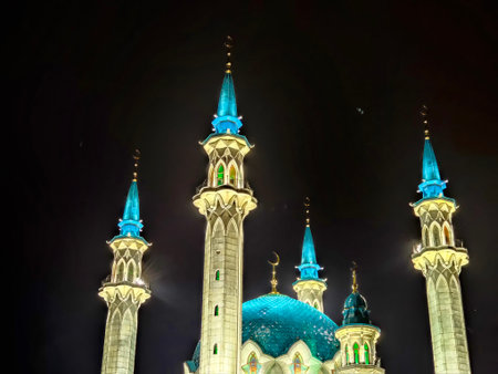 Visitors admire the Kul Sharif Mosque in Kazan at night, where vibrant lights enhance the...
