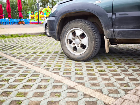 Vehicles parked on permeable pavement at an eco-friendly site, featuring colorful play areas and recreational facilities nearby.の写真素材