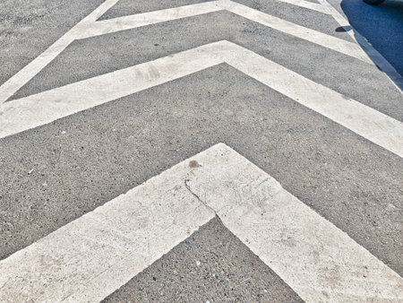 White diagonal lines on a gray surface create a bold geometric design, enhancing the urban aesthetic...