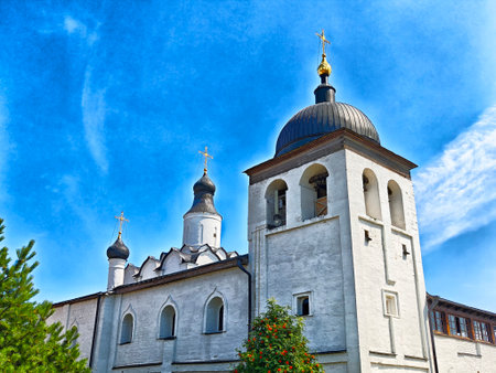 Historic church features elegant domes and crosses, surrounded by greenery under a bright blue sky,...