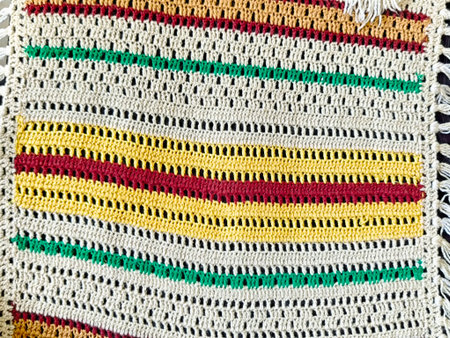 A vibrant textile showcases detailed crochet patterns with alternating colors, offering a versatile...