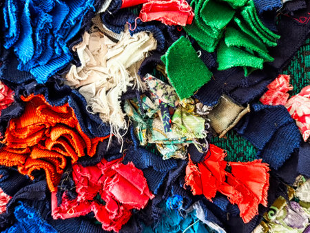 A collection of assorted fabric scraps in various colors and textures lays across a surface, showing...