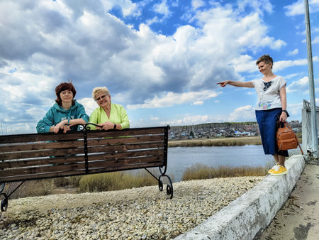 Two adults and a child enjoying a walk by the riverの写真素材