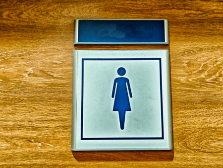 A well-designed women restroom sign is displayed on a wooden wall, indicating the location of the facilities.の写真素材