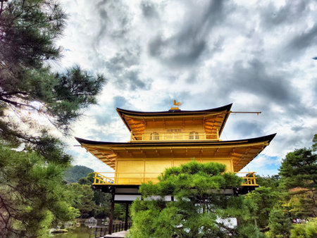 Golden Pavilion surrounded by lush greenery and water, reflecting a beautiful atmosphere in Kyoto, Japan.の写真素材