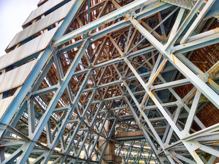Sturdy metal beams create a complex pattern beneath a large building, showcasing engineering design...