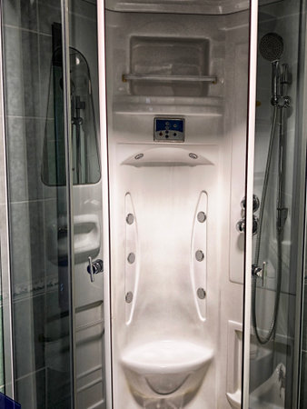 A sleek shower cabin featuring a built-in seat, multiple showerheads, and modern controls is...
