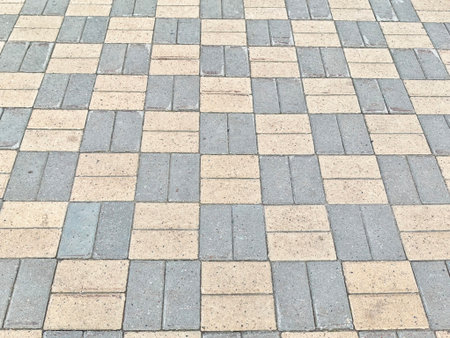 Close view of alternating light and dark paving stones forming a checkered pattern in an outdoor...