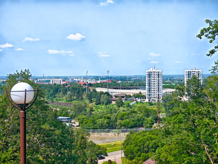Scenic overlook of Maikop with lush trees, modern architecture, and a clear blue sky, embodying springtime in Russia.の写真素材