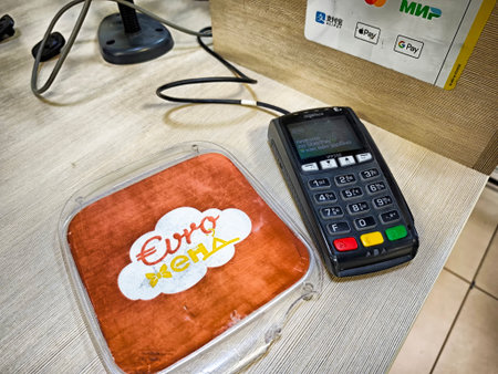 Kirov, Russia - September 10, 2025: A payment terminal sits on a counter by a soft holder,...