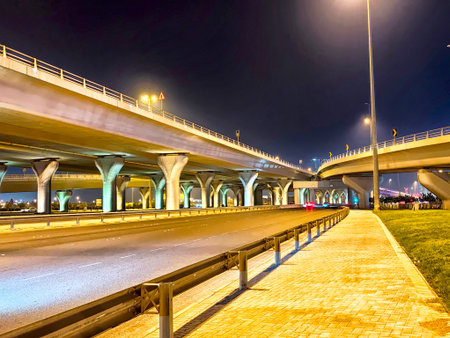 Brightly lit highway underpasses and elevated roads in Manama, Bahrain create a vibrant urban scene...