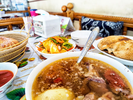 Tashkent, Uzbekistan - April 11, 2025: A hearty Uzbek meal featuring steaming soup, fresh salad, warm bread, and flavorful condiments was enjoyed in Tashkent.のeditorial素材