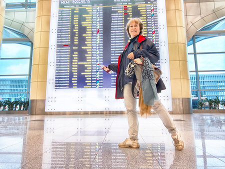 Moscow, Russia - September 27, 2025: A person waits at a Moscow airport, checking flight status on a large display board while preparing for their next journey.のeditorial素材