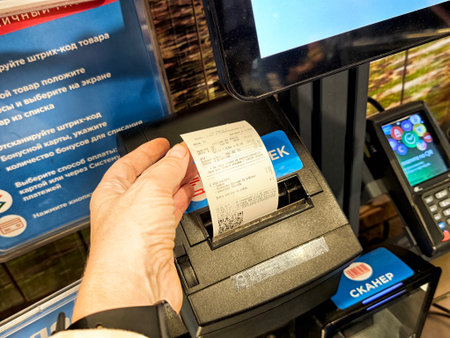 Kirov, Russia - August 06, 2025: Customer uses self-service machine to print receipt after scanning...
