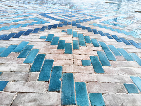 Colorful tiles create a beautiful mosaic pattern on the ground, reflecting sunlight and creating a calming atmosphere by the water.の写真素材