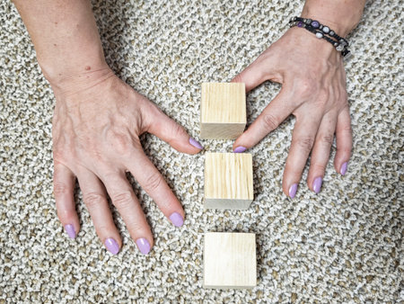 Hands building simple structure from wooden blocks. Concept of strategy, organization, planning...