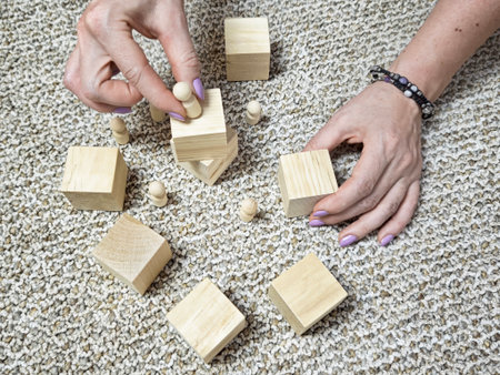 Hands rearranging wooden blocks and figures. Concept of solving problems, changing strategy,...