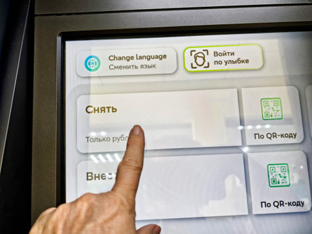 Kirov, Russia - August 26, 2025: A person is using a touchscreen kiosk to select payment options. The screen displays various choices in Russian.のeditorial素材