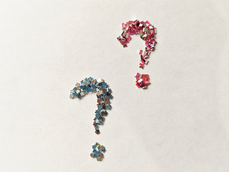 Minimal abstract composition with question mark formed from pink decorative crystals on white...