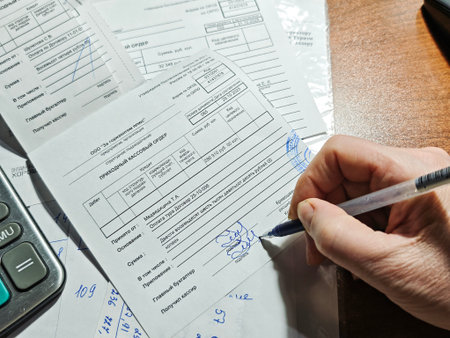 Kirov, Russia - January 07, 2025: Hand signing Russian cash expense voucher document with pen,...