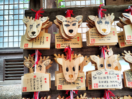 Japan, Nara - October 29, 2024: Colorful wooden plaques in deer shapes display messages and wishes from visitors at a shrine in Nara, Japan.のeditorial素材