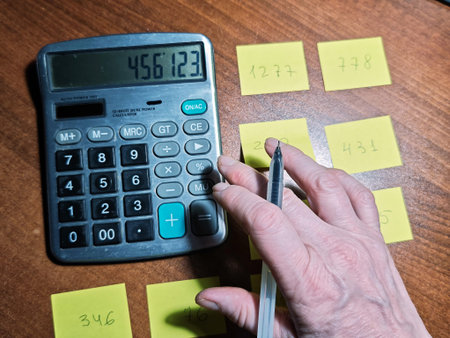 Hands calculating expenses with calculator and paper notes on desk, accounting mistakes, financial...