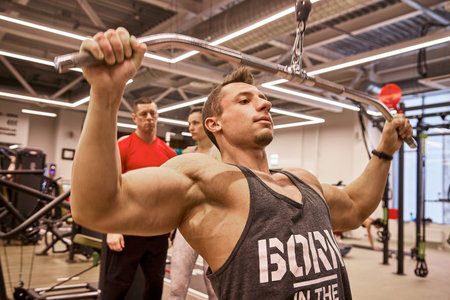 Kirov, Russia - March 15, 2021: Men and women train at a gym while performing exercises that focus on building strength and muscle tone during the day.のeditorial素材