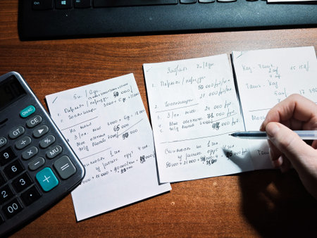 Kirov, Russia - January 30, 2026: Person calculates household budget and expenses at home using a...
