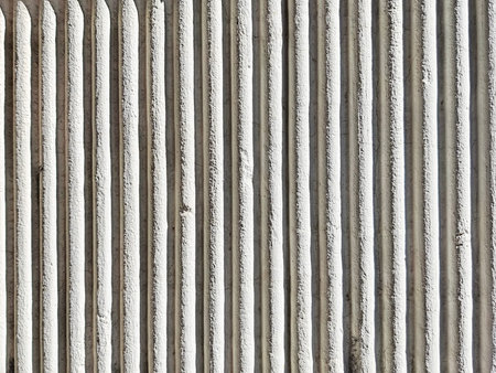 Vertical grooves on a textured concrete wall create a clean, modern background perfect for graphic...