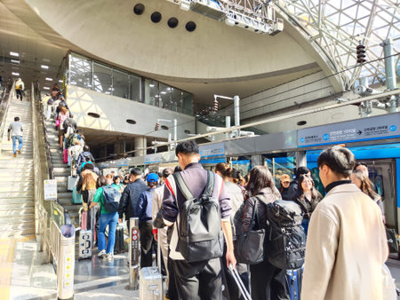 Seoul, South Korea - November 02, 2024: Travelers with luggage line up to board a train at the...