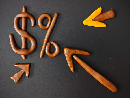 Clay dollar with rising and falling arrows on dark background illustrating interest rate changes,...