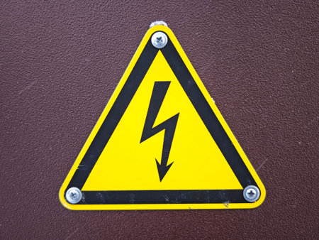 A yellow triangular caution sign shows a lightning bolt symbol to warn about electrical danger. It...