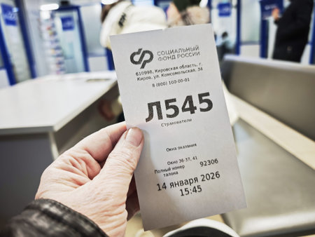 Kirov, Russia - January 14, 2026: A person holds a ticket number while waiting in a government...