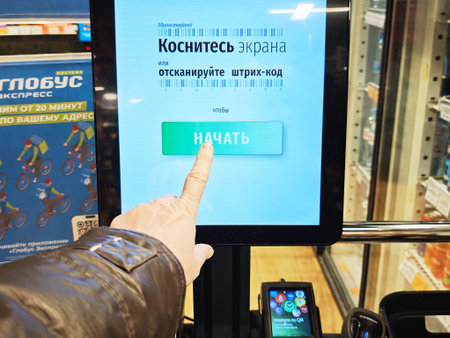 Kirov, Russia - January 29, 2026: A customer points at the screen of a self checkout terminal in a...