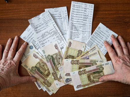 Kirov, Russia - January 22, 2026: Hands are sorting Russian ruble cash and shopping receipts on a...