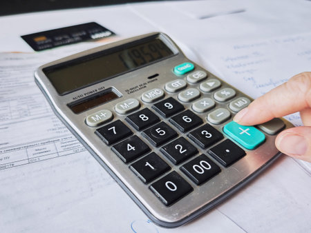 Kirov, Russia - March 18, 2026: A person is using a calculator to manage household finances and...