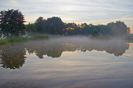 Fog at sunrise over a pondの写真素材