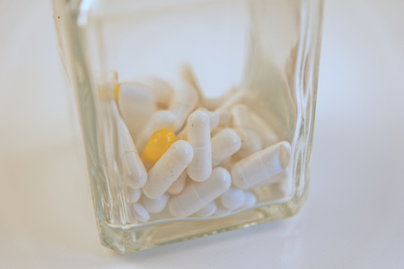 Pills for health in glass on white backgroundの写真素材