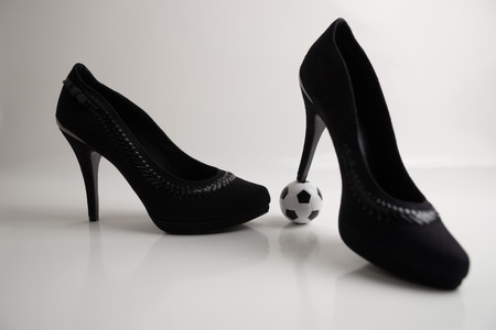 Soccer ball and high heels, isolated on white backgroundの写真素材