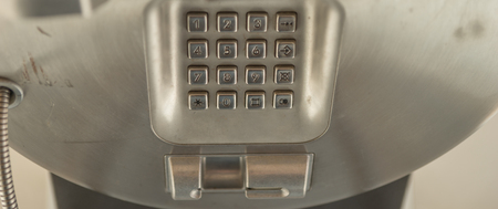 dial number button on old used public telephoneの写真素材