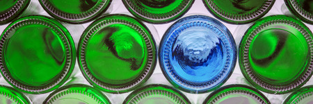 Glass blue bottle among green bottles. Concept of differenceの写真素材
