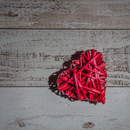 Red wood heart on rustic wooden background