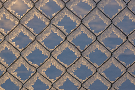 Chain-link fence with snow, winter background, abstract urban design