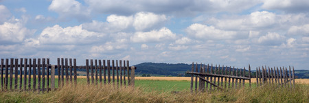 Damaged fence with mountains in the backgroundの写真素材