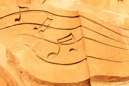 Drawn musical notes on a sandy beachの写真素材