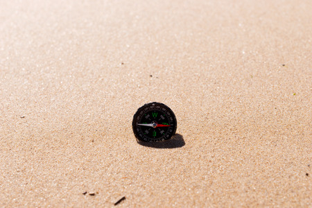 Compass on the sea sand at the beach