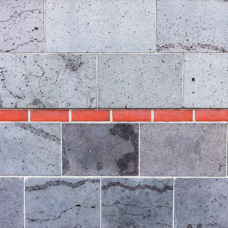 Gray wall, interrupted by red bricksの写真素材