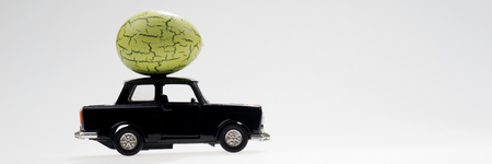 Big green easter egg on the black carの写真素材