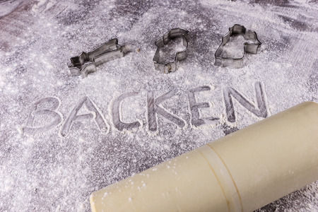 Baking (Backen) in German letters written in flour on the tableの写真素材