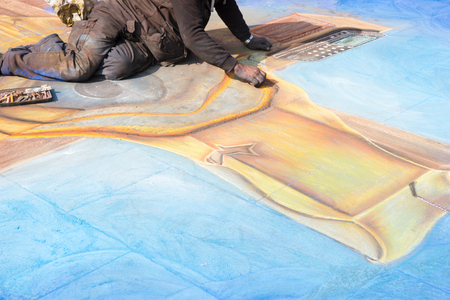Street art - Male street artist working with chalk at a pictureの写真素材